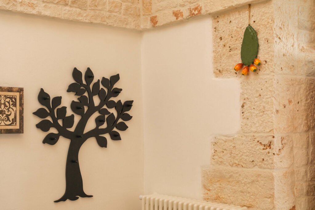 Dettaglio del soggiorno con pietra a vista e decoro a forma di albero